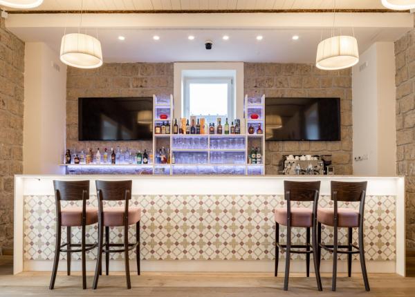 Elegante bar con sedie in legno e pareti in pietra.