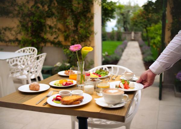 Colazione all'aperto con piatti vari e cappuccino.